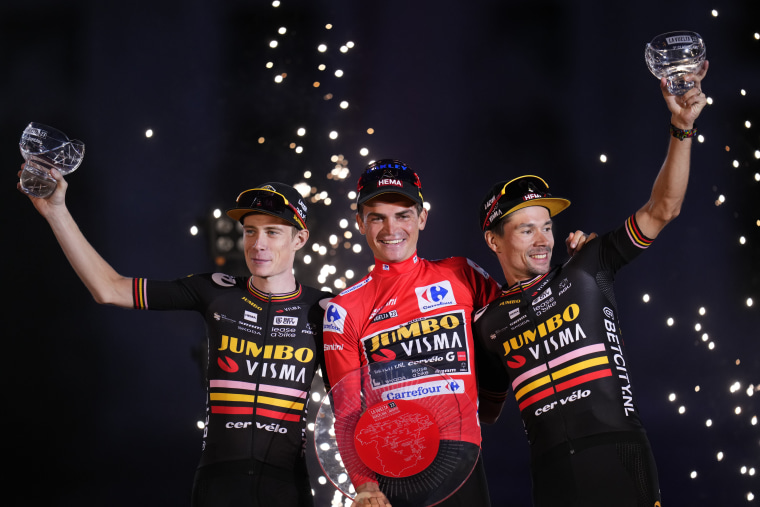 Sepp Kuss, center, celebrates in Madrid, Spain, with Jumbo-Visma teammates after winning the Spanish Vuelta on Sunday, Sept. 17, 2023. Jonas Vingegaard, left, finished second and Primoz Roglic finished third.