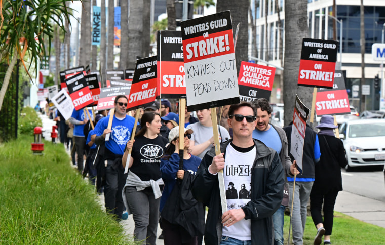 Members of the Writers Guild of America walk the picket line in front of Netflix in Hollywood, Calif.,