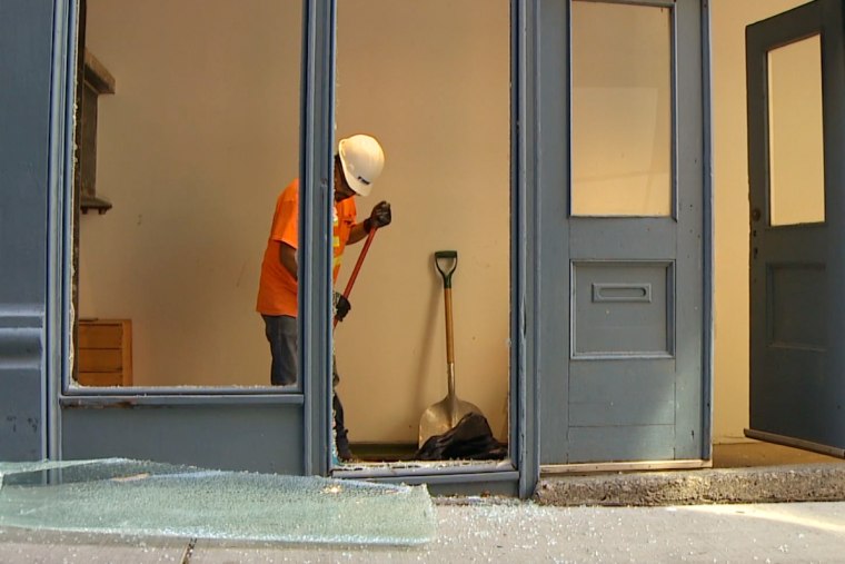 A worker removes the broken glass at Wing Luke Museum.