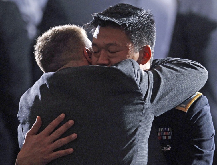 Lt. Dan Choi, a gay Army officer honorably discharged under "don't ask, don't tell," receives a hug before President Barack Obama signs the act lifting the ban on homosexuals serving openly in the U.S. armed forces at the Department of the Interior on Dec. 22, 2010.