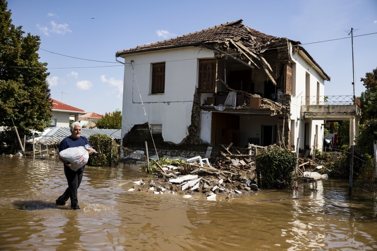 A man walks in front of a destroyed house in the flooded village of Palamas, Greece, on Sept. 8, 2023.