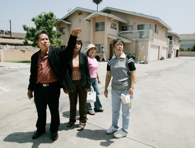 Former sweatshop workers from left, Win Chua Ngan, his wife Sukanya Choai Ngan, Boonlai Vancura and Sangwan Jane, who were forced to work as garment workers in the apartment complex behind them, gathered on Aug. 2, 2005 for the 10 year anniversary since 72 Thai nationals were liberated in El Monte, Calif. 