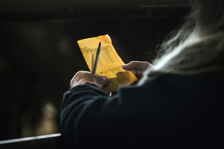 A woman reviews her bidding card during an auction of wild horses in Beaumont, Texas in 2021.
