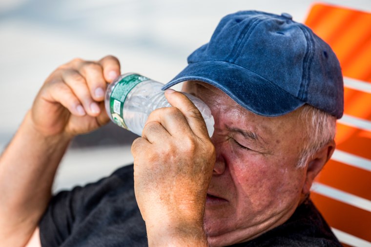 A parkgoer cools himself with a cold bottle of water in Astoria, N.Y., on July 12, 2023.