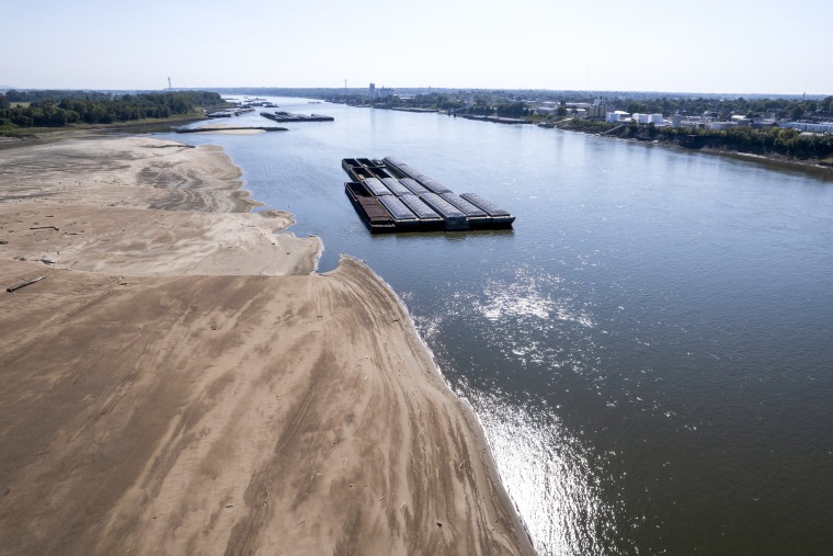 Barges float in the Mississippi River as a portion of the riverbed is exposed in St. Louis, Mo., on Sept. 15, 2023.