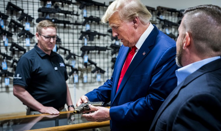 Former President Donald Trump examines a customized Glock pistol decorated with his name and likeness during a visit the Palmetto State Armory in Summerville, S.C., on Sept. 25, 2023.