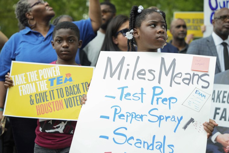 Children carry signs to protest against the state takeover of the Houston Independent School District