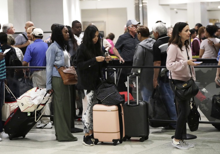 Passengers wait in line at a security checkpoint at Miami International Airport in Miami amid a government shutdown in 2019. 