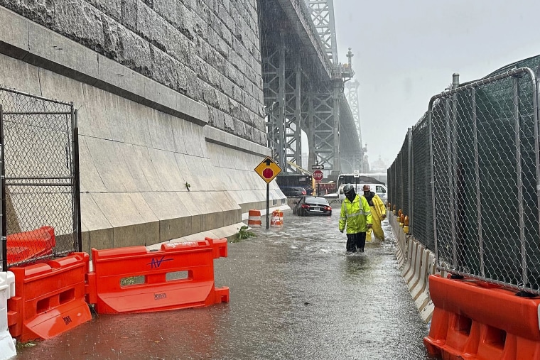 First responders wade through flood waters at the base of the Williamsburg Bridge, Friday, Sept. 29, 2023, in New York. 