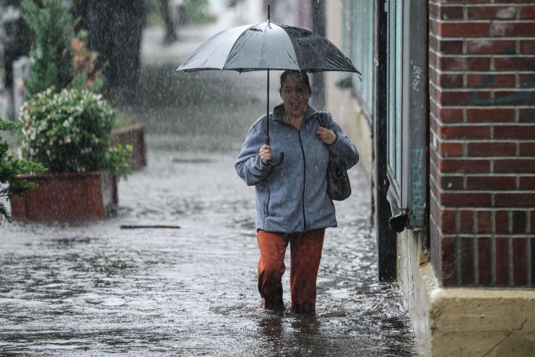 A woman walks through through floodwaters in Brooklyn, N.Y., on Sept. 29, 2023. 