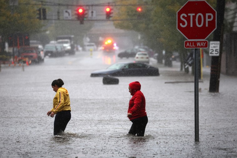 Residents walk through floodwaters in Mamaroneck, N.Y., on Sept. 29, 2023.