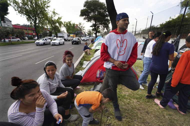 Carlos León, de Venezuela, espera con su familia en una parada de ómnibus en la Ciudad de México, el 22 de septiembre de 2023.