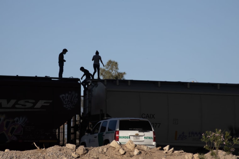 Tres jóvenes migrantes que viajaban en un tren de mercancías que cruzaba la frontera fueron descubiertos por la patrulla fronteriza y se les pidió que bajaran del tren en Ciudad Juárez, Chihuahua, México, en 2021.