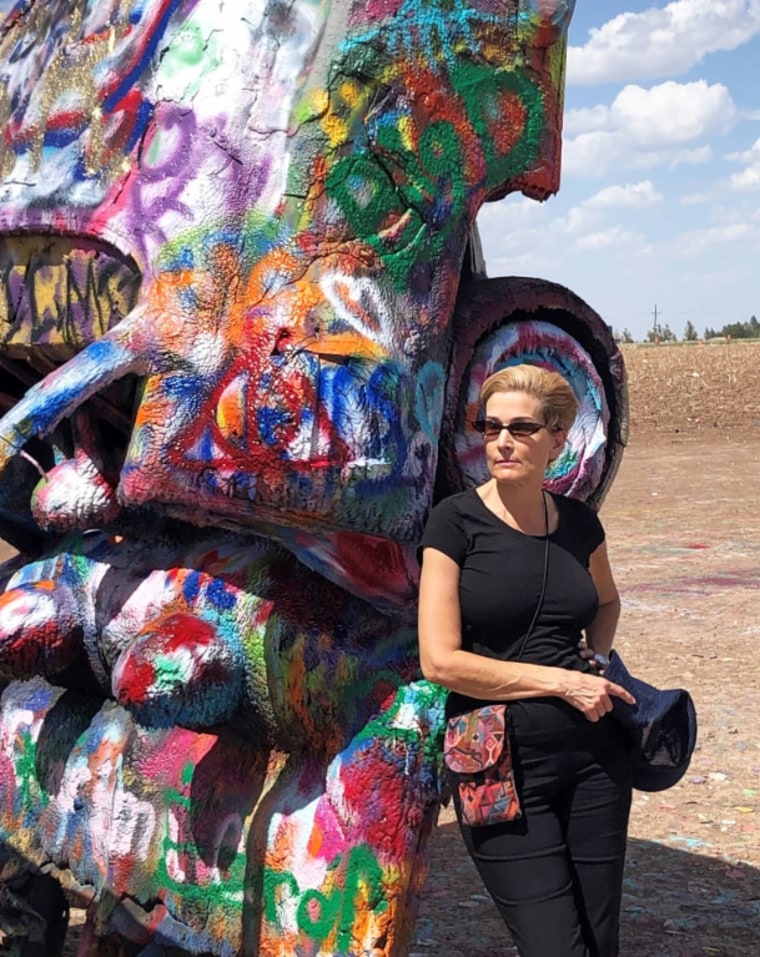 En el Rancho Cadillac, en Texas, Leslie Stone pintó un auto con la frase "Viaje por carretera 2022", para celebrar su vida sin cáncer.