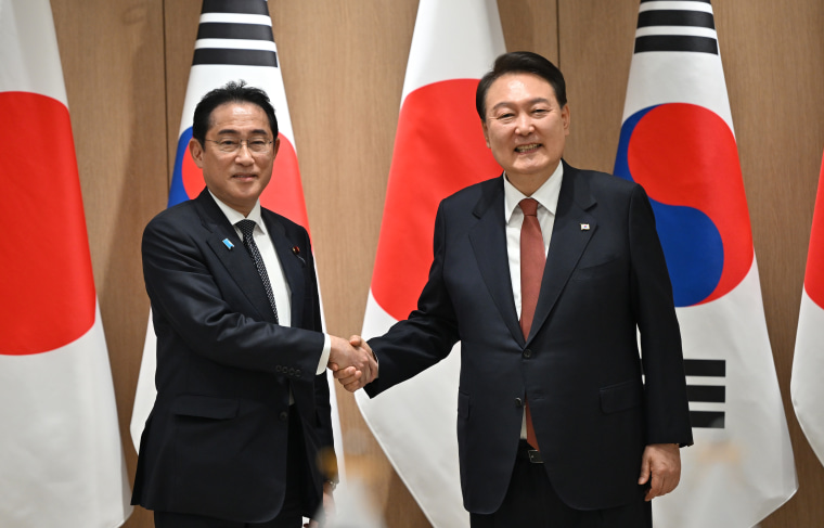 South Korean President Yoon Suk Yeol (R) shakes hands with Japanese Prime Minister Fumio Kishida (L) during their meeting at the presidential office on May 7, 2023 in Seoul, South Korea. 