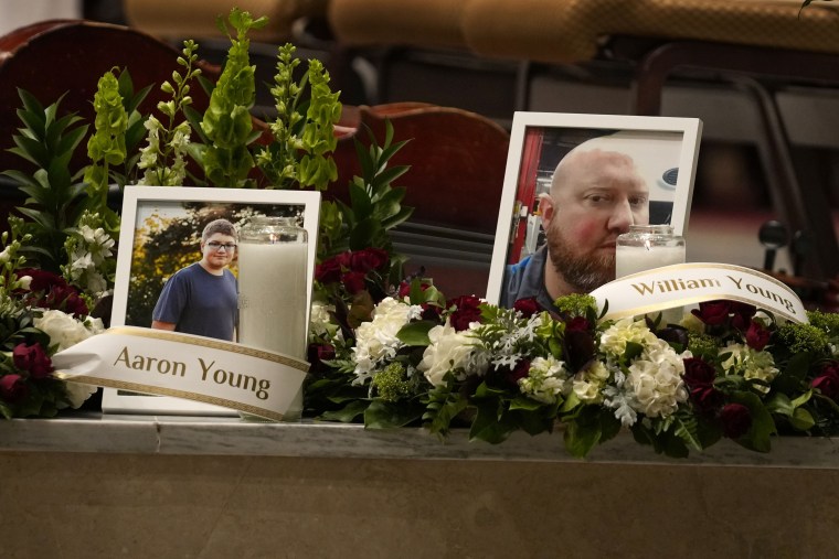 Photos of Aaron Young and his father, William Young, are displayed  Sunday at a vigil for the victims of Wednesday's mass shootings at the Basilica of Saints Peter and Paul in Lewiston, Maine. 