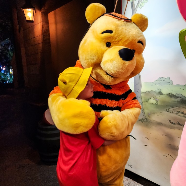 Drew Patchin hugs Winnie the Pooh at Disney World.
