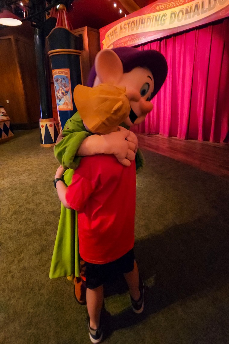 Drew Patchin hugs one of the Seven Dwarves at Disney World.