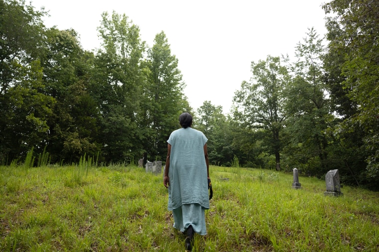 Lacretia Johnson Flash walks near tombstones on land that has been in her family for generations in Perry County, Linden, Tenn., on July 19, 2023.