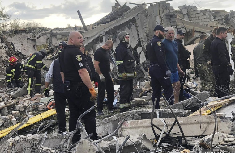 Emergency workers search for victims of the deadly Russian rocket attack that killed more than 40 people in the village of Hroza near Kharkiv, Ukraine.