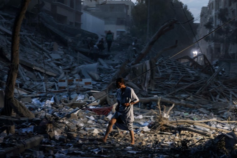 A man walks atop the rubble of a tower destroyed in an Israeli air strike in Gaza City on Oct. 7, 2023.