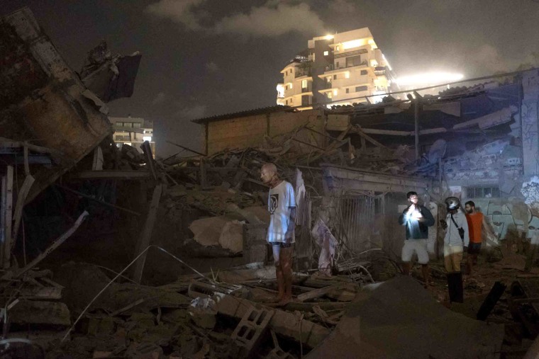Image: People look through rubble in Tel Aviv.