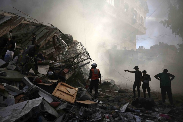 Image: Residents assess destruction from Israeli airstrikes in Gaza City.