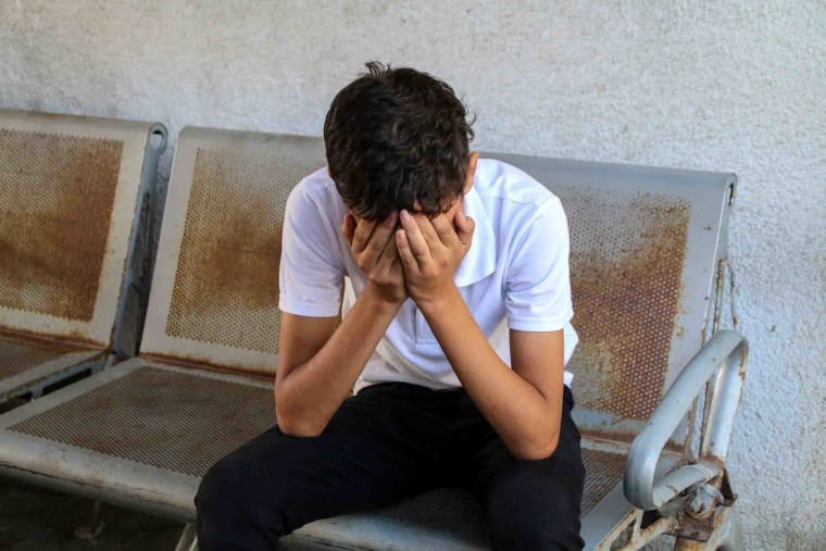 Image: A young man cries during a farewell to Palestinian fighters at the Al-Shifa Hospital in Gaza City.