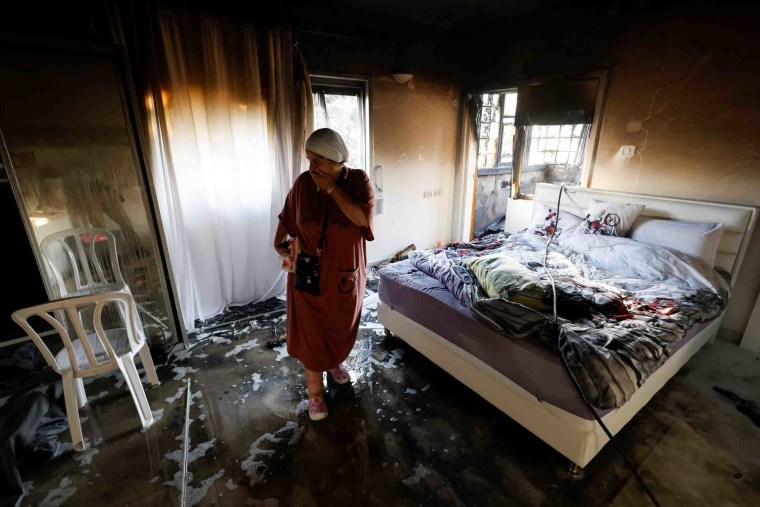 IMage: A woman weeps in a damaged room in Ashkelon.