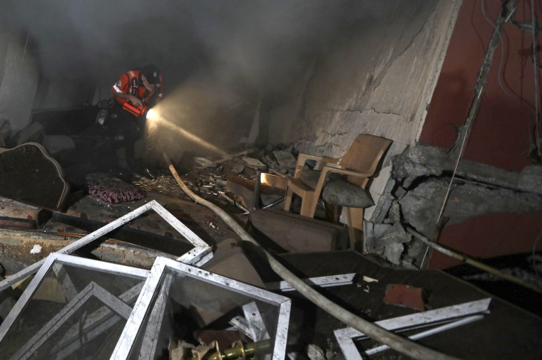 Image: A member of the civil defense crew searches a damaged house in Khan Younis, near the southern Gaza Strip, on Sunday.