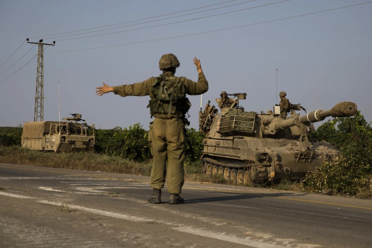 Image: An Israeli soldier directs armored vehicles toward the southern border with the Gaza Strip in Sderot on Sunday.