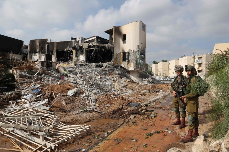 Soldiers stand in front of an Israeli police station on October 8, 2023, that was damaged during battles to dislodge Hamas militants in Sderot, Israel.