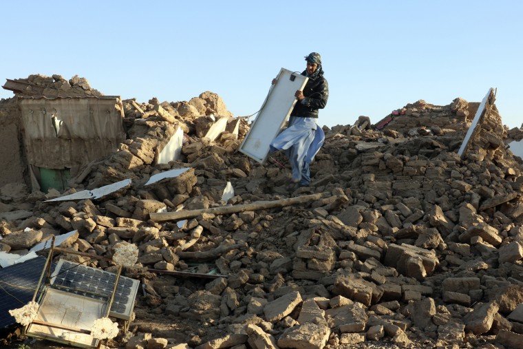 An Afghan man removes debris after an earthquake in Afghanistan
