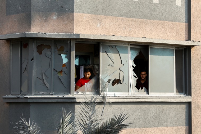 Image: Residents look through a damaged window of a house in the southern Gaza Strip on Monday.