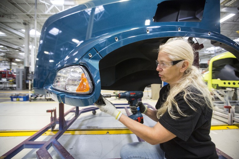 Colleen Miller, a production technician on the hood line, assembles a Mack Truck at the company's plant in Macungie, Pa.