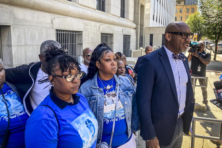 Image: Attorney Mawuli Davis flanked by relatives of Johnny Holman Sr. 