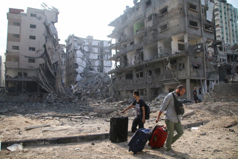 Palestinians evacuate their homes damaged by Israeli airstrikes in Gaza.