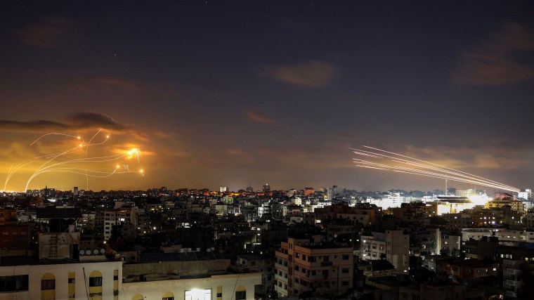 Israel's Iron Dome, left, intercepts rockets fired from Gaza, right, on October 10, 2023.