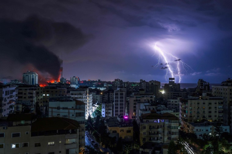 Image: Lightning strikes as smoke billows following an Israeli airstrike in Gaza City on Oct. 9, 2023.