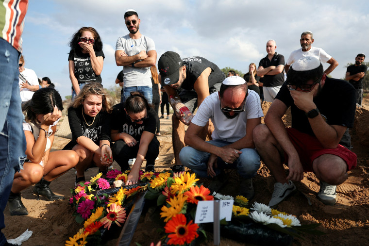 People mourn at the graveside of Guez at her funeral in Ashkelon