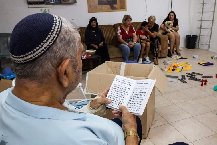 An Israeli man reads from the Torah as people take shelter during a rocket attack in Ashkelon on Oct. 10, 2023.