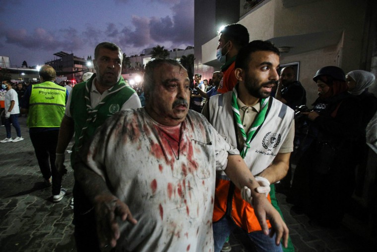 Paramedics help a wounded man walk into Al-Shifa hospital in Gaza.