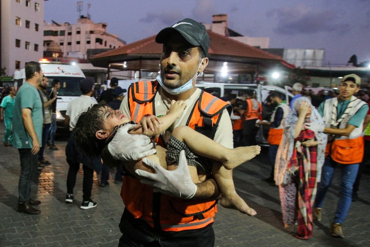 An emergency responder carries a wounded child into Al-Shifa hospital in Gaza on Oct. 11, 2023.