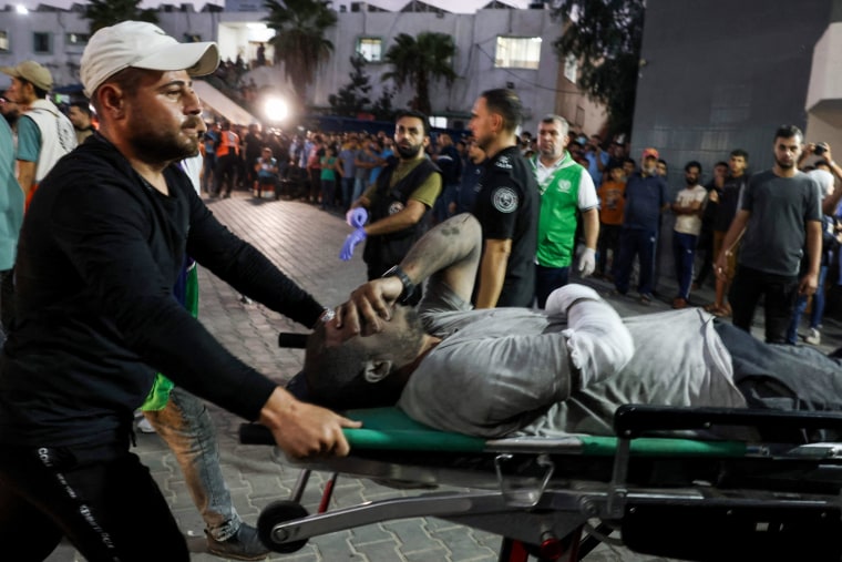 Medics transport an injured man into Al-Shifa hospital in Gaza.
