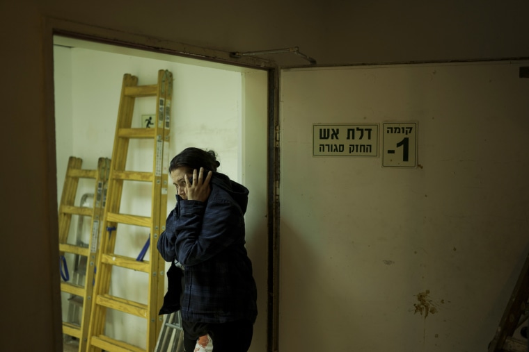 A woman covers her ears during incoming rocket fire from Gaza in Ashkelon, Israel.