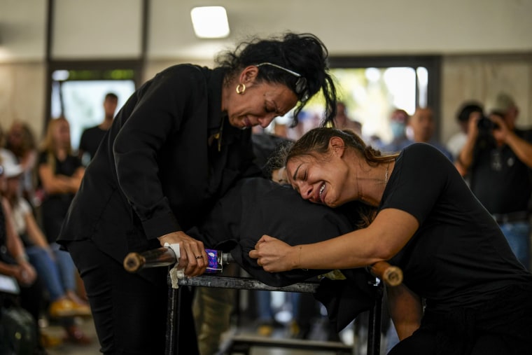 Mourners cry over the body of Mapal Adam during her funeral in Tel Aviv on Oct. 11, 2023.