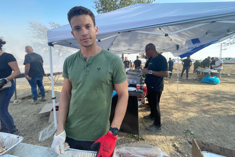 Omer Shacham, 24, busily prepares food for soldiers near the Gaza border as they prepare to fight.