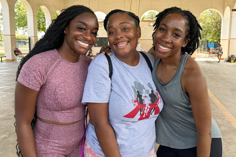 Quannecia McCruse stands between two of her friends, Faith Adjei-Sarpong, left, and Precious Uwaezuoke, at the Sickle Cell Houston Walk in September
2023.