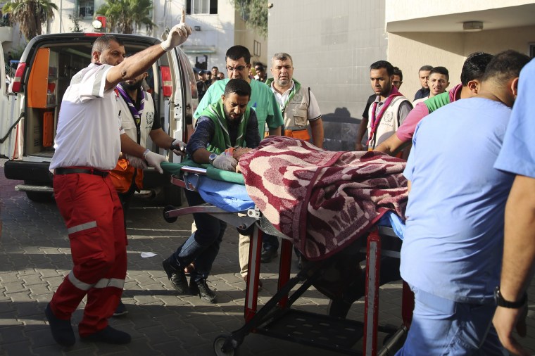 Medics push a wounded Palestinian into a hospital on a stretcher