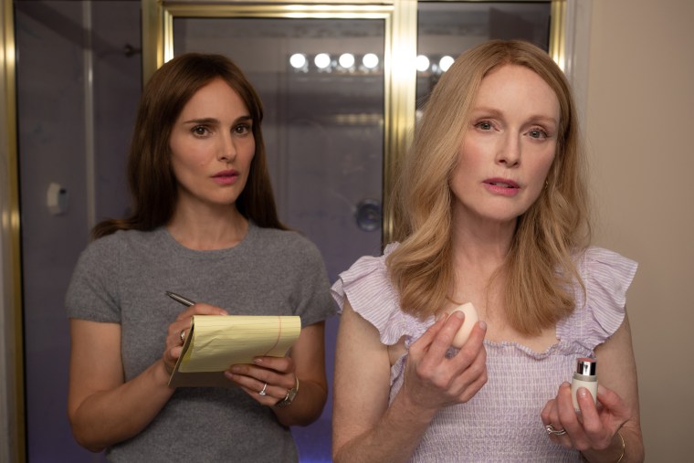 Natalie Portman observes Julianne Moore as they both look in a mirror during a scene in "May December"